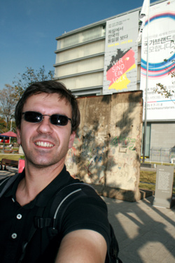 Ein Stück Berliner Mauer in Seoul vor dem Plakat 'Wir sind ein Volk'.