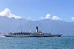 Ein Passagierschiff auf dem Genfersee mit den Berge Frankreichs im Hintergrund.