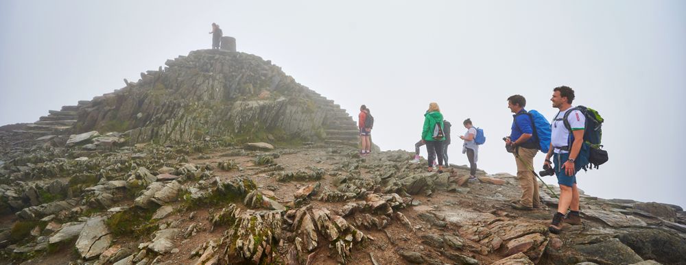 Schlange stehen und Abstand halten für das neblige Gipfelfoto auf unserem ersten Peak - dem Snowdon (1085 m).** Schlange stehen und Abstand halten für das neblige Gipfelfoto auf unserem ersten Peak - dem Snowdon (1085 m).**